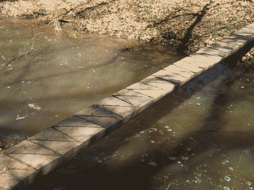 Footbridge across the river with carved zigzag patterns
