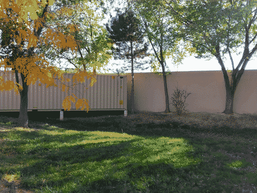 Shipping container at the edge of the sump at the bottom of the Sweetwater Harvest parking lot