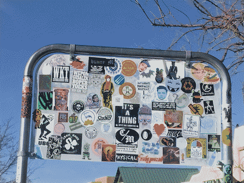 The back of a sign on a shopping cart repository at the Co Op: a smattering of liberal cultural references from bike clubs and pot shops to antifascism and feminism